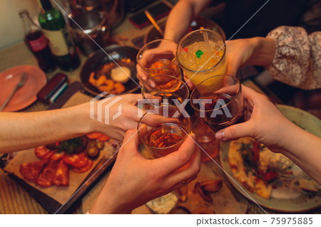 Clinking glasses with alcohol and toasting, party. 75975885