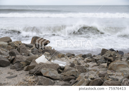 Plastic trash washed ashore 75976413