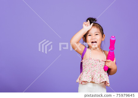 Happy Asian little girl holding plastic water gun 75979645