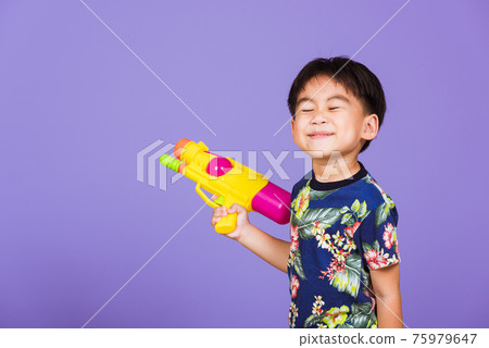 Thai kid funny hold toy water pistol and smiling 75979647