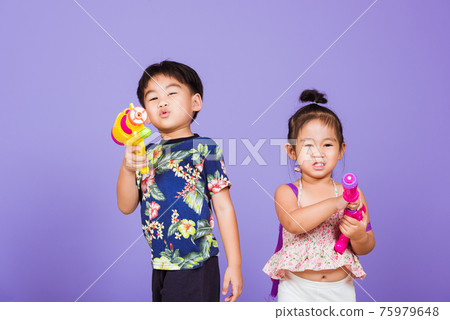 Two Happy Asian little boy and girl holding plastic water gun 75979648