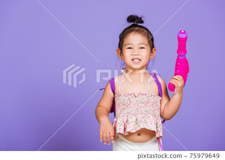 Thai child funny hold toy water pistol and smile 75979649