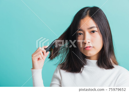 woman upset with a comb and problem hair woman upset with a comb and problem hair 75979652