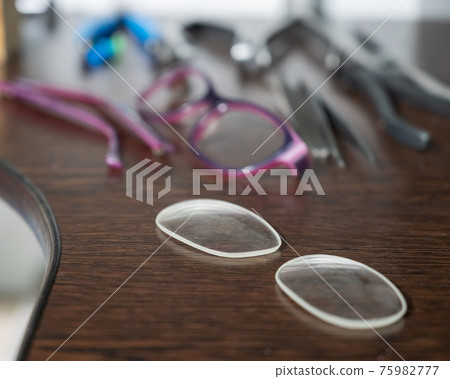 Optical technician work table. Close-up of lens frames and screwdrivers. 75982777