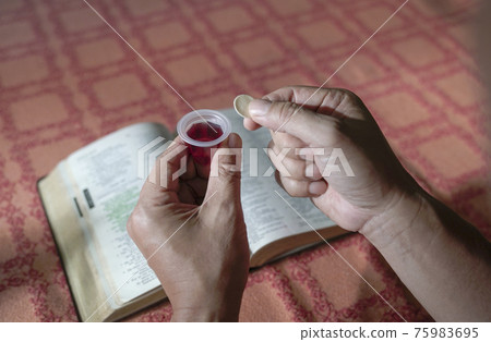 Man holding bread and wine in Hoy Communion. 75983695
