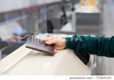 Faceless woman at the airport holding out passport assistant to the check-in counter. Faceless woman at the airport holding out passport assistant to the check-in counter. 75984320