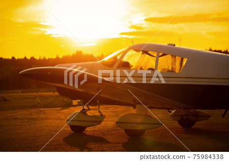 Landed small four-seater airplane at sunset background. Landed small four-seater airplane at sunset background. 75984338
