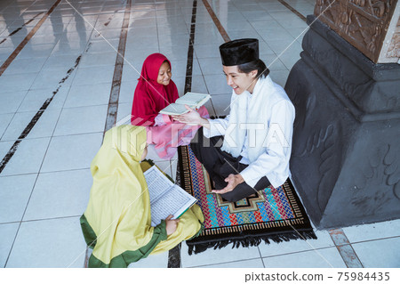 two kids learning to read quran with muslim teacher or ustad 75984435