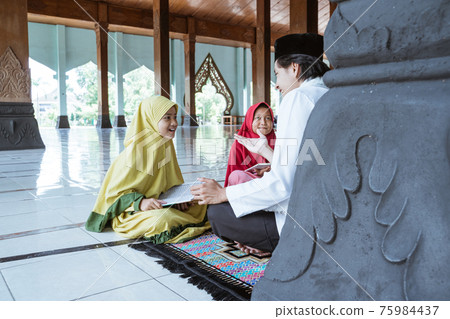two kids learning to read quran with muslim teacher or ustad 75984437