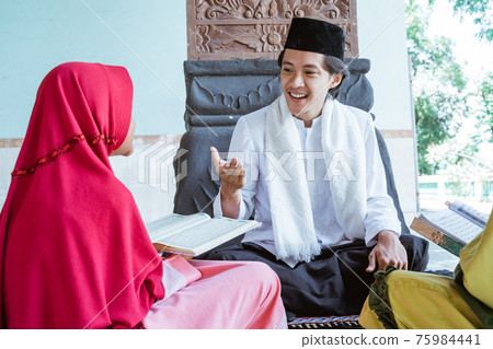 Portrait asian Muslim male teachers teach two girls to read the Quran 75984441