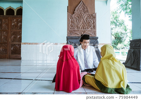 Portrait asian Muslim male teachers teach two girls to read the Quran 75984449