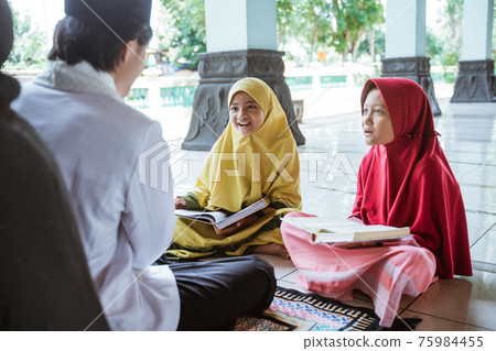 two kids learning to read quran with muslim teacher or ustad 75984455