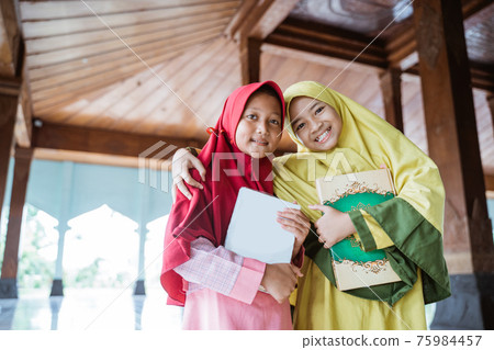 asian kids woman Muslim holding al quran book and hug each other 75984457