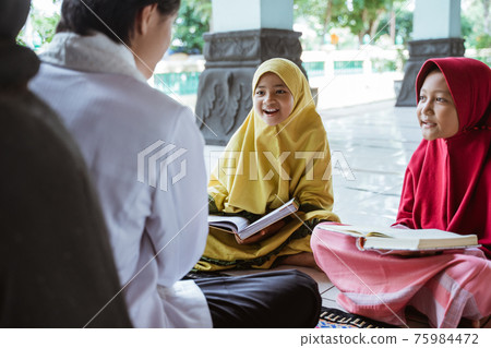 two kids learning to read quran with muslim teacher or ustad 75984472