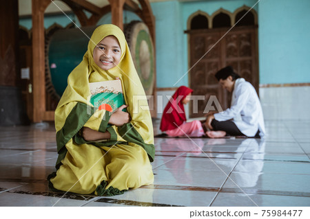 asian girl muslim smiling holding al quran book and learning to read quran with muslim teacher aur ustad 75984477
