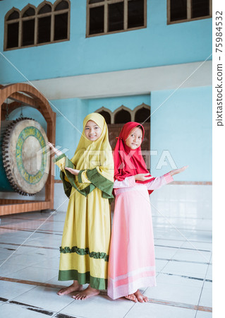 Two kid girl asian Muslim smiling showing something 75984532