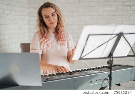 Remote music lessons. A singing teacher records the lesson on a laptop webcam. Remote music lessons. A singing teacher records the lesson on a laptop webcam. 75985254