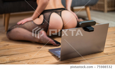 Faceless young woman in lingerie and on laptop web camera. The girl works as a web mobile and masturbates for the camera Faceless young woman in lingerie and on laptop web camera. The girl works as a web mobile and masturbates for the camera 75986532