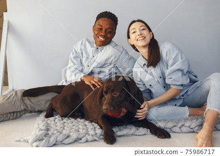 International couple on a blue background with a dog 75986717