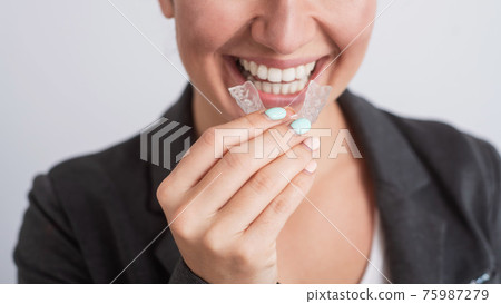 Business woman uses transparent braces to whiten teeth Business woman uses transparent braces to whiten teeth 75987279