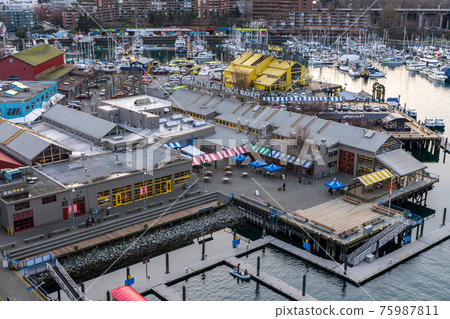 Granville Island Public Market, Marina and Fishermen's Wharf Float in dusk. Vancouver city buildings skyline in the background. Vancouver, Canada. 75987811