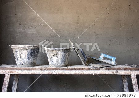 Equipment for building cement walls placed on wooden planks on the construction site, including unfinished cement walls. Equipment for building cement walls placed on wooden planks on the construction site, including unfinished cement walls. 75987978
