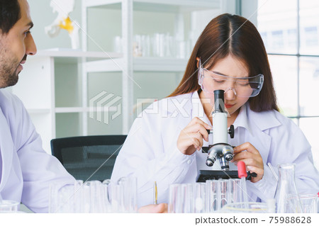 Doctor and microbiologist with vacuum tubes for samples with COVID 19 infection atypical pneumonia virus in laboratory Doctor and microbiologist with vacuum tubes for samples with COVID 19 infection atypical pneumonia virus in laboratory 75988628