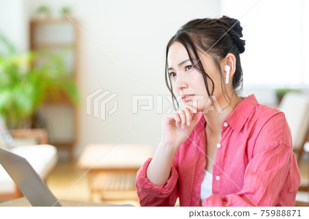 Young woman doing telework in the living room Young woman doing telework in the living room 75988871
