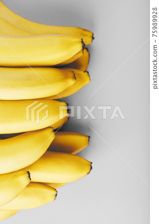 Fresh bunch of yellow bananas isolated on a Gray background Trendy colors of 2021 Fresh bunch of yellow bananas isolated on a Gray background Trendy colors of 2021 75989928