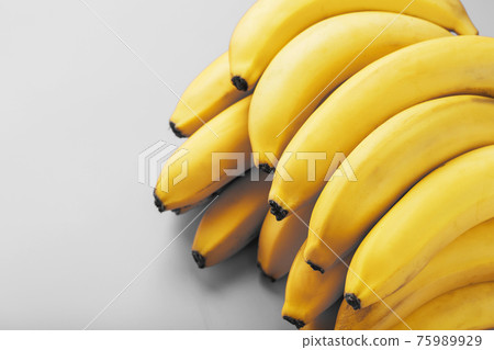 Fresh bunch of yellow bananas isolated on a Gray background Trendy colors of 2021 Fresh bunch of yellow bananas isolated on a Gray background Trendy colors of 2021 75989929