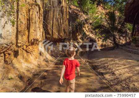 Boy tourist on the Fairy stream among the red dunes, Muine, Vietnam. Vietnam opens borders after quarantine COVID 19 75990457