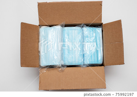 Disposable face masks in a package . Medical mask in the box ready to shipment. 75992197
