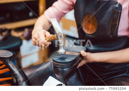 Close-up of woman shoemaker repairing some shoes 75993204
