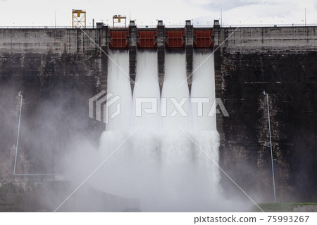 Water flowing over floodgates of a dam at Khun Dan Prakan Chon Water flowing over floodgates of a dam at Khun Dan Prakan Chon 75993267