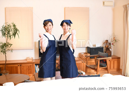 膽量姿勢的兩名微笑的管家婦女 膽量姿勢的兩名微笑的管家婦女 75993653