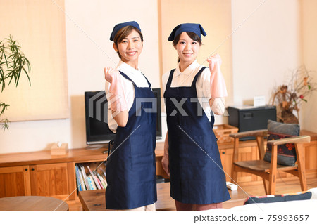膽量姿勢的兩名微笑的管家婦女 膽量姿勢的兩名微笑的管家婦女 75993657