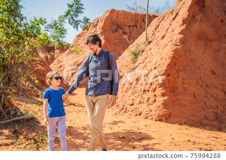 Dad and son tourists in red canyon, resumption of tourism concept. Traveling with children concept Dad and son tourists in red canyon, resumption of tourism concept. Traveling with children concept 75994288
