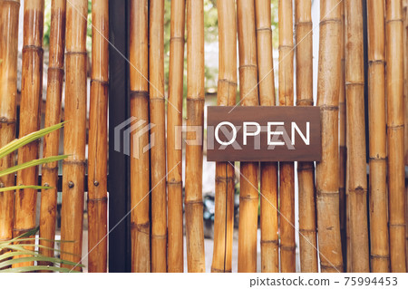A business sign that says open on cafe or restaurant hang on door at entrance. 75994453