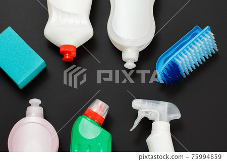 Bottles of washing liquid, brush and sponge on a black background. 75994859