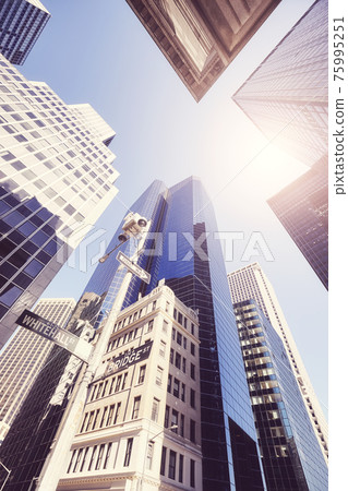 Looking up at New York skyscrapers against the sun, color toned picture, USA. Looking up at New York skyscrapers against the sun, color toned picture, USA. 75995251