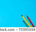 Green, Yellow and Red Pencils on Blue Background 75995694