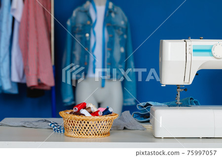 Electric sewing machine in a seamstress office 75997057