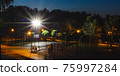 Green night empty playground in park with bright spotlight on blue background. Evening city urban landscape. Nobody in summer public place. Sport, healthy lifestyle. Recreation scene view 75997284