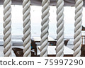 Closeup of strong string white ropes on background sea and deck. Abstract sailor marine backdrop. Textured twisted vertically fiber line 75997290