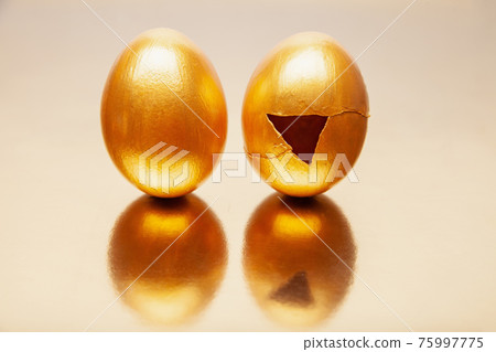Whole and cracked Golden eggs placed on reflective table Whole and cracked Golden eggs placed on reflective table 75997775