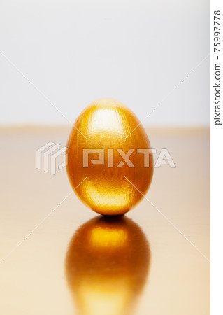 Whole Golden eggs placed on reflective table Whole Golden eggs placed on reflective table 75997778