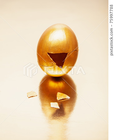 Golden egg with triangle hole placed on reflective table Golden egg with triangle hole placed on reflective table 75997788