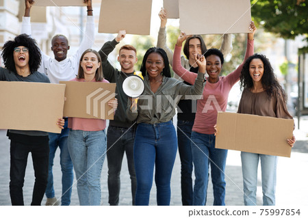 Positive international students walking by street with empty placards Positive international students walking by street with empty placards 75997854