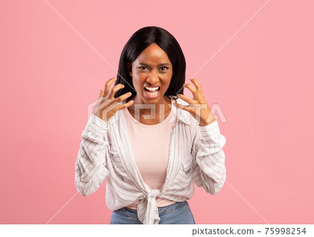 Angry black woman screaming out loud, tired of her problems, expressing negative emotions over pink studio background 75998254