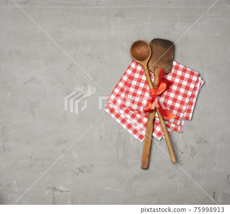 old spoon and spatula tied with red ribbon on a gray background old spoon and spatula tied with red ribbon on a gray background 75998913